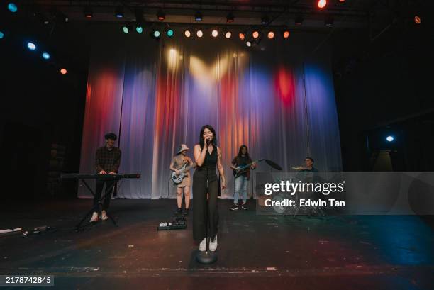 young asian chinese lead singer and live band multiracial group performance on stage - pop rock - fotografias e filmes do acervo
