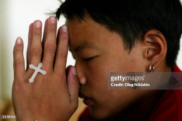 Young Catholic Mongolian prays during a children's mass at St. Mary's Church July 19, 2003 in Ulan Bator, Mongolia. After the Catholic mission...