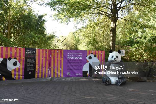 Giant panda sculpture is set in front of the banner reading that "The two newly arrived giant pandas will make their public debut in January." at the...