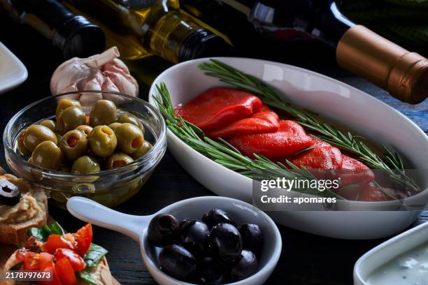 geräucherter pfeffer in einer mit olivenöl gewürzten schüssel, begleitet von verschiedenen vorspeisen - mediterrane kultur stock-fotos und bilder