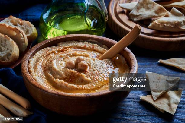 chickpea hummus in a bowl garnished with paprika and olive oil. - tahini stock pictures, royalty-free photos & images