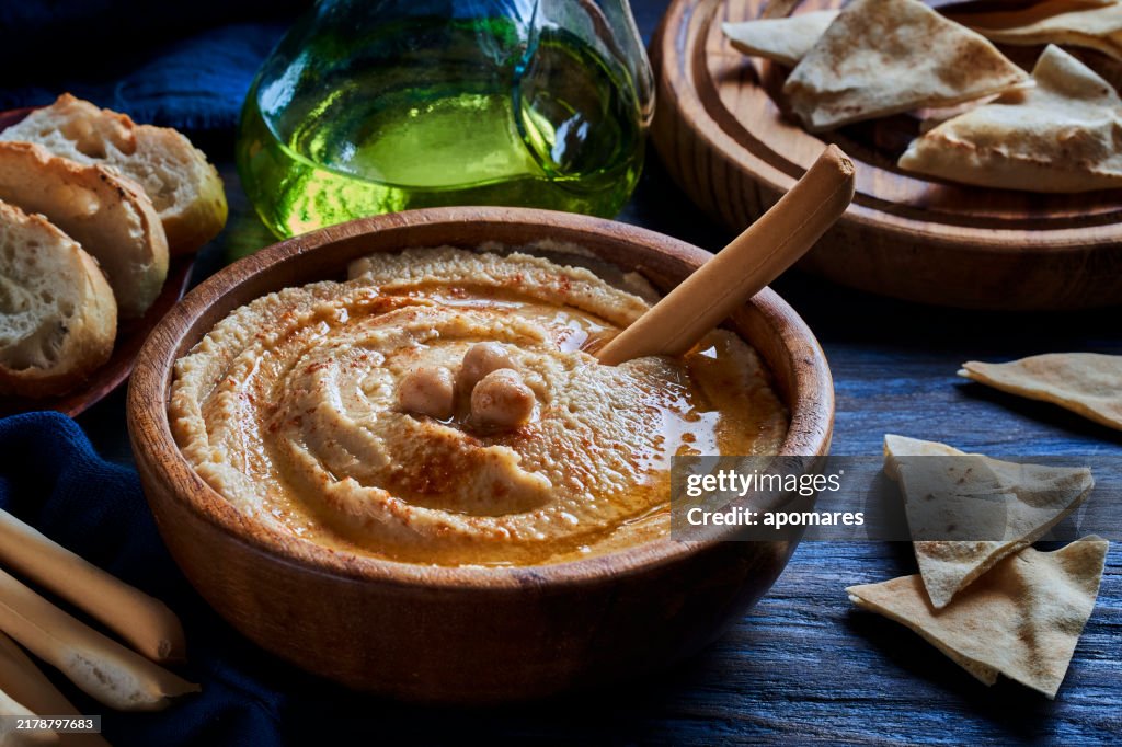 Chickpea hummus in a bowl garnished with paprika and olive oil.