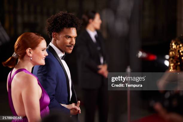 candid shot showcases the movie stars' genuine reactions as they face the paparazzi. - evento com traje de cerimónia imagens e fotografias de stock