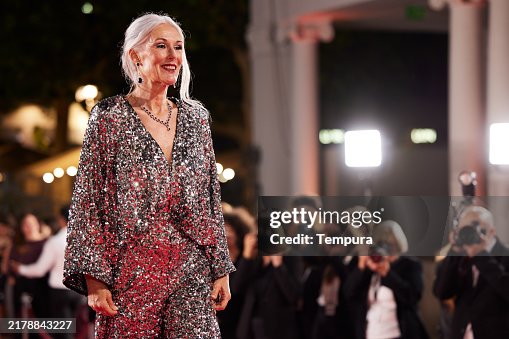 Smiling actress in shiny gown posing at event. Smiling actress in shiny gown posing at event.