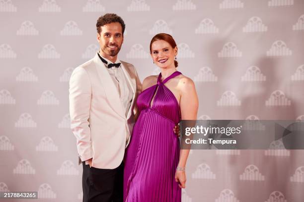 ein lächelndes schauspielerpaar posiert für ein porträt bei einer glamourösen veranstaltung auf dem roten teppich. - premiere stock-fotos und bilder