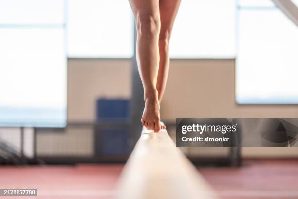 gymnast woman performing on balance beam - gymnast stock pictures, royalty-free photos & images