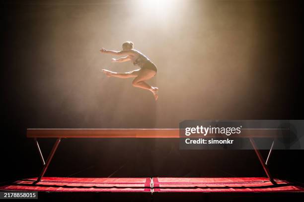 gymnast woman performing on balance beam - gymnastics equipment stock pictures, royalty-free photos & images