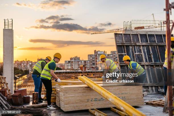 bauarbeiter, die auf einer baustelle arbeiten - baustelle stock-fotos und bilder
