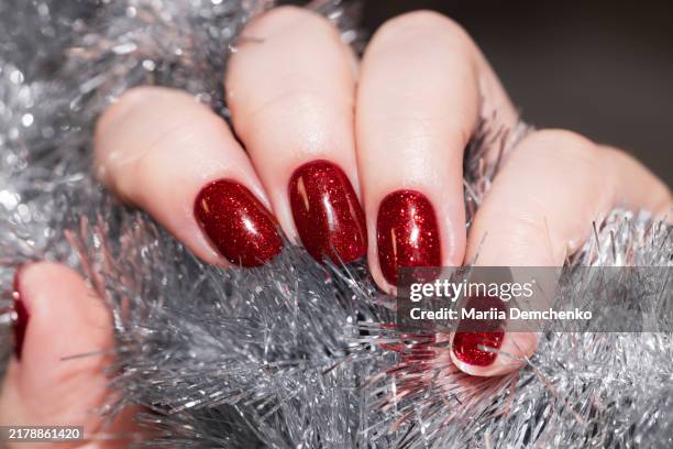hand with red glitter gel fingernails, holiday manicure - manicura de diseño fotografías e imágenes de stock