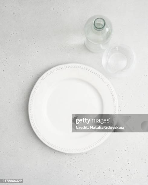 clean empty white plate, fork and knife on pastel grey table, copy space, mock up, vertical - leerer teller stock-fotos und bilder