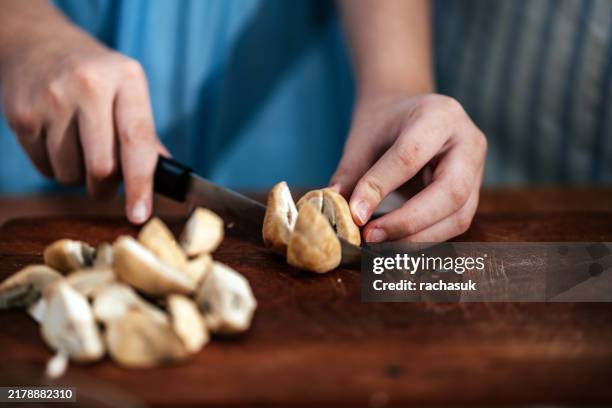 teenage girl hands chopping straw mushroom - straw mushroom stock pictures, royalty-free photos & images