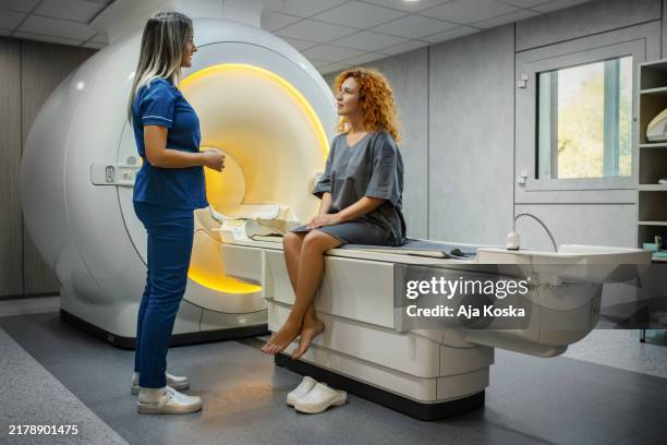 il tecnico medico prepara il paziente per la risonanza magnetica. - figura intera foto e immagini stock