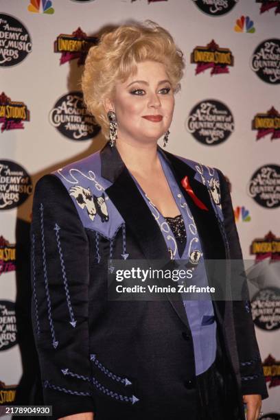 American actress Delta Burke, wearing a black-and-purple Western-style outfit, in the 27th Annual Academy of Country Music Awards press room at...