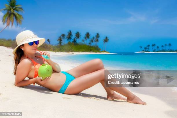 cute hispanic young woman sunbathing on a white sand tropical beach - pina colada stock pictures, royalty-free photos & images