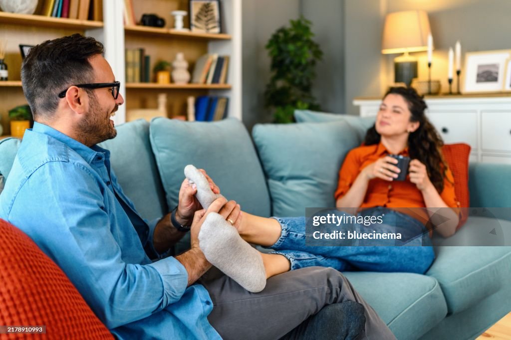 Man making feet massage to his wife