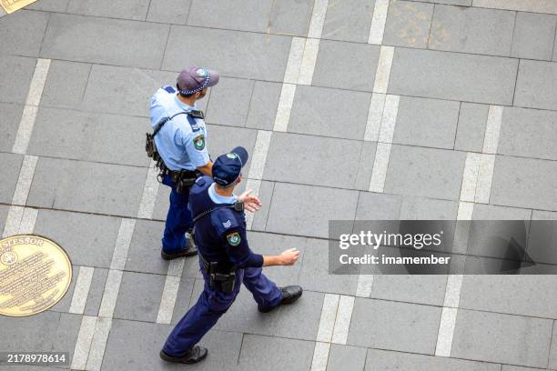 elevated view of two nsw police officers patrolling street in sydney - rescue services occupation stock pictures, royalty-free photos & images