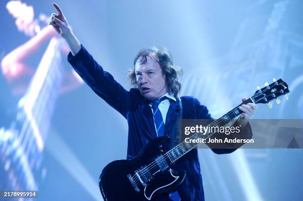 Australian Rock musician Angus Young, of the group AC/DC, plays electric guitar as he performs onstage at Erwin Center, Austin, Texas, November 6,...