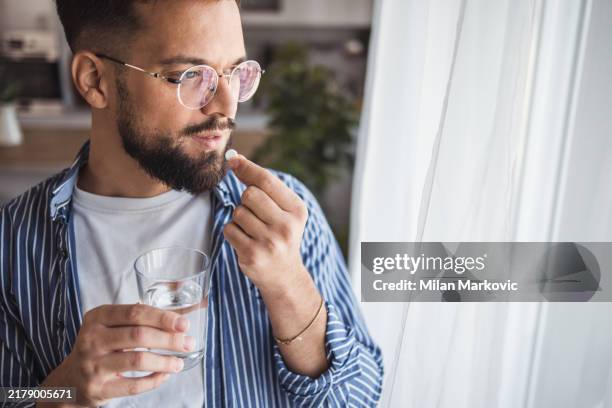 rituale di cura mattutina - un momento di attenzione per se stessi con un bicchiere d'acqua e una vitamina - prendere-le-pillole foto e immagini stock