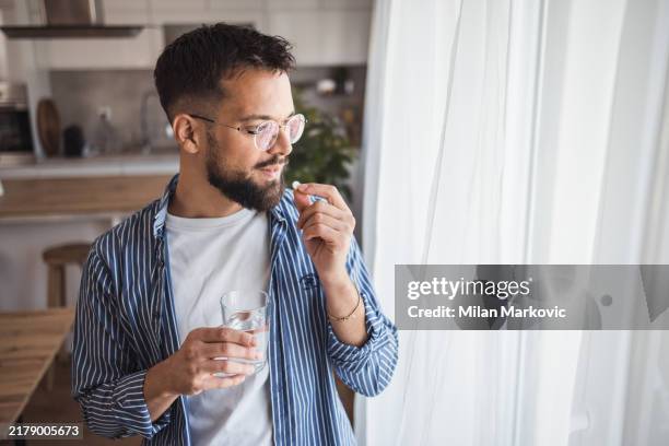 rituale di cura mattutina - un momento di attenzione per se stessi con un bicchiere d'acqua e una vitamina - attività che richiedono movimento foto e immagini stock