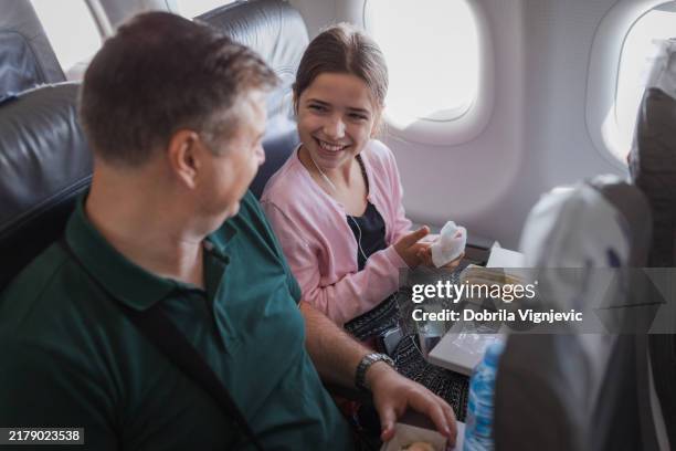 girl laughing when having a sandwich with her father at a plain - wet wipe stock pictures, royalty-free photos & images