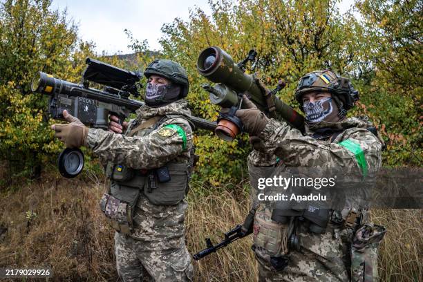 Two Ukrainian soldiers check the scopes of their anti-aircraft systems to ensure they're working properly before heading out on a mission in Donetsk...
