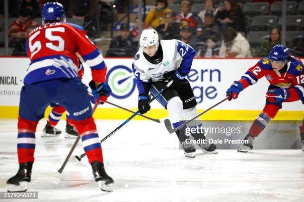 William Yared of St John Sea Dogs stick handles the puck with Simon Mullen of the Moncton Wildcats and Aiden Diamond of the Moncton Wildcats...