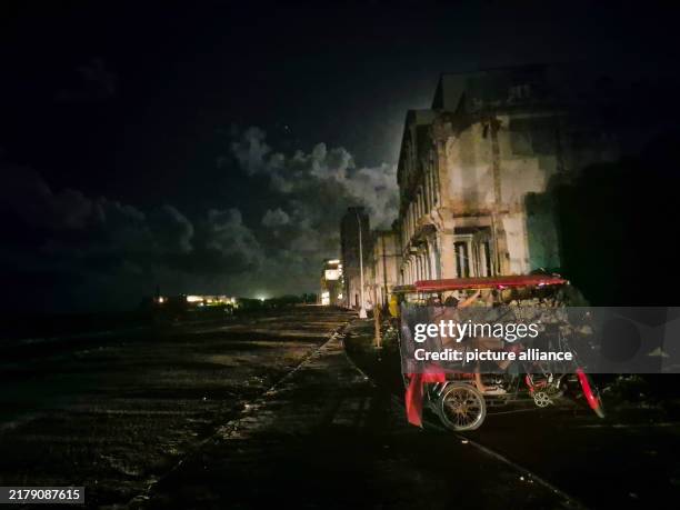 October 2024, Cuba, Havanna: During an island-wide power cut, two men sit in a bicycle cab. Photo: Nick Kaiser/dpa