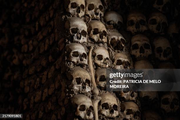 Picture taken on October 20, 2024 in Evora, central Portugal shows the human skulls and bones that cover the walls of the Chapel of Bones, inside the...