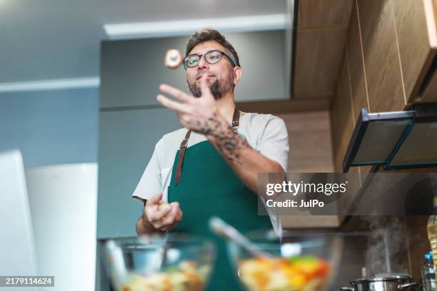 mid adult man cooking salad with mushrooms - mushroom tattoos stock pictures, royalty-free photos & images