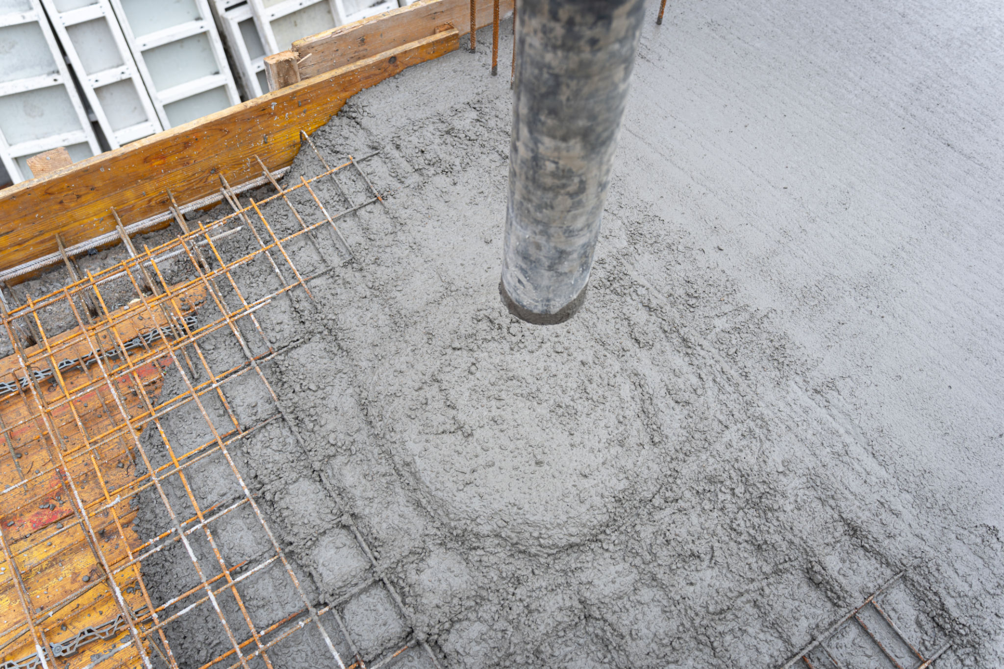 Reinforcing bars with wet cement in the process of pouring a concrete floor Reinforcing bars with wet cement in the process of pouring a concrete floor