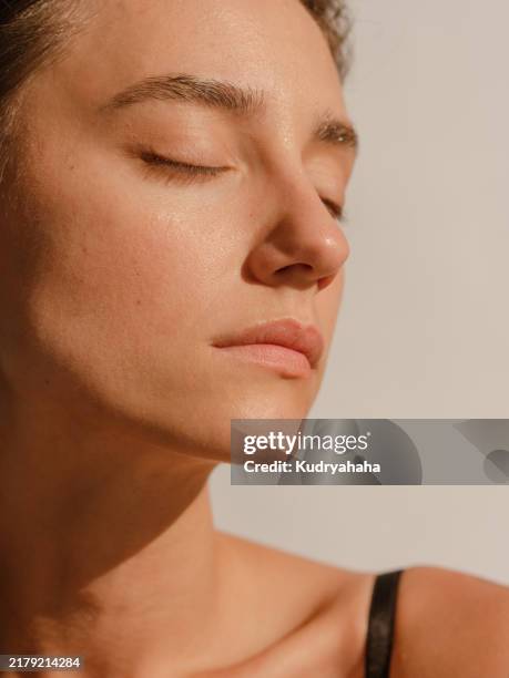 close-up portrait of a woman with clean, moist skin in the sunlight - caratteristica della pelle foto e immagini stock