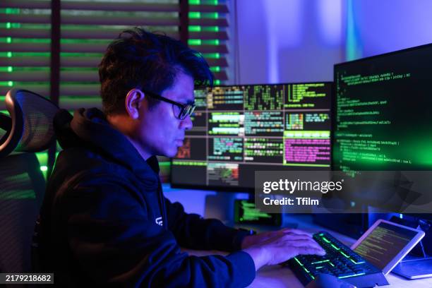 hacker typing code in neon-lit workspace - privacy rule stock pictures, royalty-free photos & images