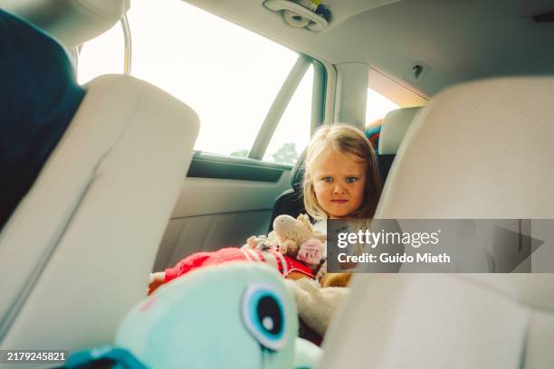 girl sitting in the car and making faces while being on vacation. - être motorisé photos et images de collection