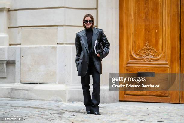Diane Batoukina wears black Dior sunglasses, a black top, a black leather jacket, a black leather Chanel bag, black pants, black leather pointed...