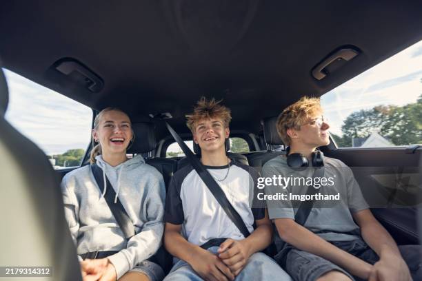 adolescenti che viaggiano sul sedile posteriore attraverso la città di dinan, bretagna. - cintura di sicurezza foto e immagini stock