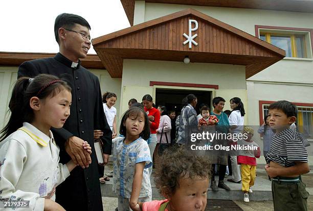 Stefanus, a Catholic priest, talks with young congregants after a mass at St. Mary's Church July 20, 2003 in Ulan Bator, Mongolia. After the Catholic...
