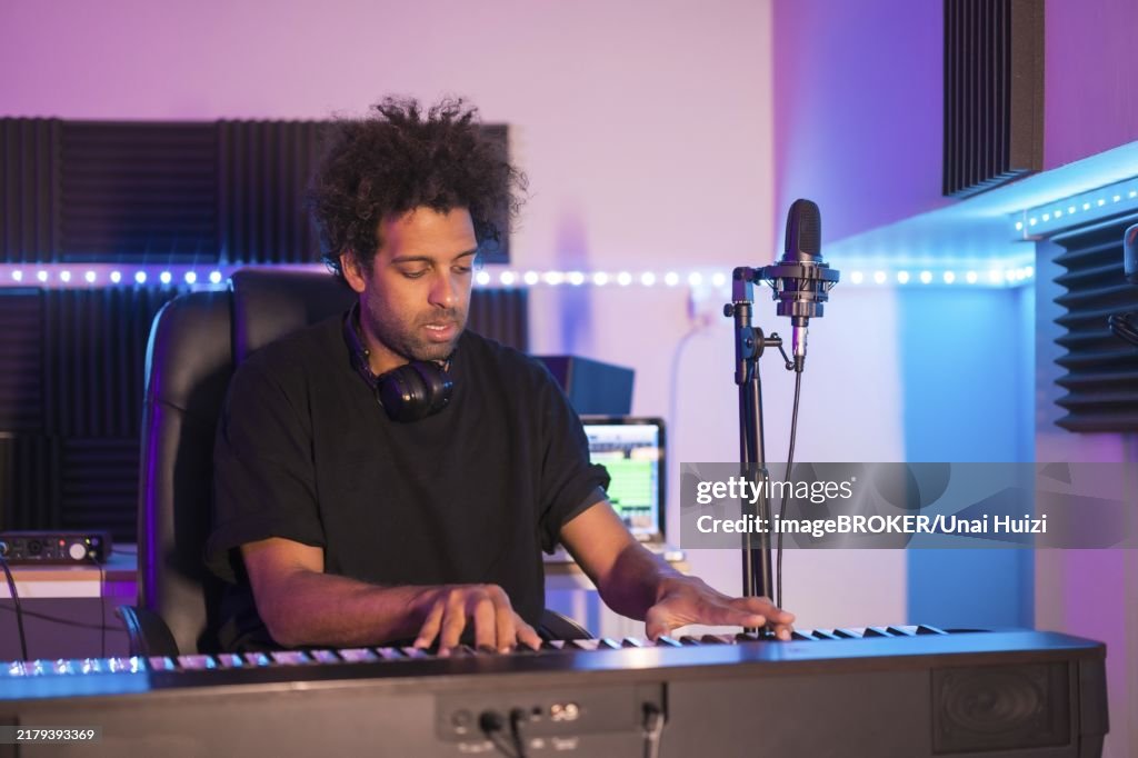 Frontal view of a musician playing the piano in a production studio