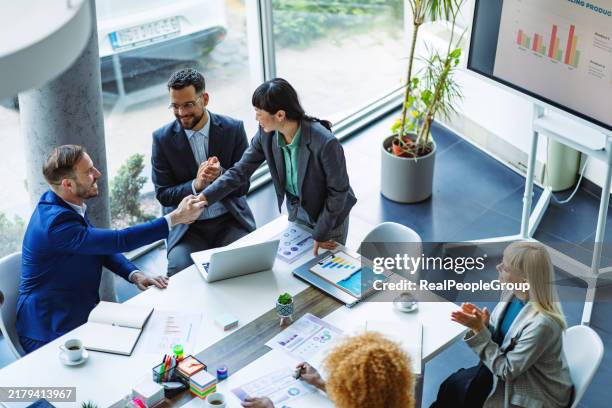 business meeting handshake at modern office table. - woman-man-handshake-across-table stock pictures, royalty-free photos & images