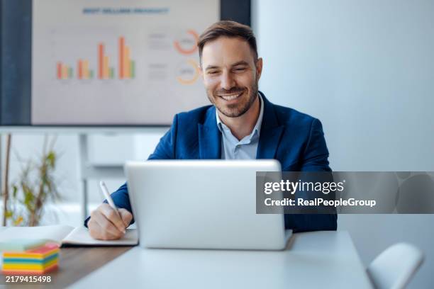 smiling businessman working on laptop in office. - finance director stock pictures, royalty-free photos & images