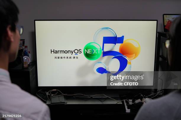 Woman and her children watch the "Huawei Harmony OS operating system released" in Shanghai, China, October 22, 2024 That night, China's first...