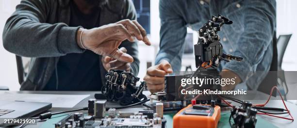 black and white male software developer programmers work together on robot hand machine coding, use computer control robotic arm circuit. programming language, hardware development technology concept - menselijke robot stockfoto's en -beelden