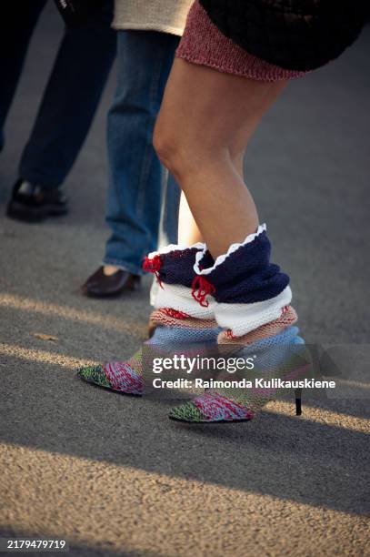 Guest wears red knotted mini skirt and long multicolour knitted boots during the 10th season of the Visa Fashion Week Almaty on October 18, 2024 in...
