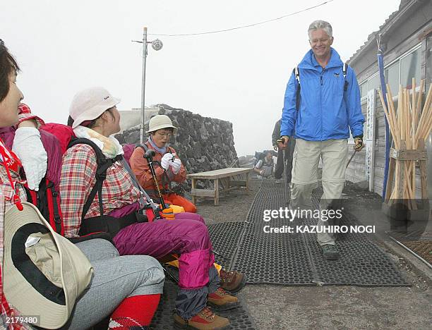 Hartwig Gauder , former German Olympic champion, walks past Japanese female visitors as he climbs Mt. Fuji with a transplanted heart to appeal to the...