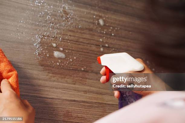 close-up of woman hand cleaning the surface of a wood table with a cleaning cloth at home - trapo de limpiar el polvo fotografías e imágenes de stock
