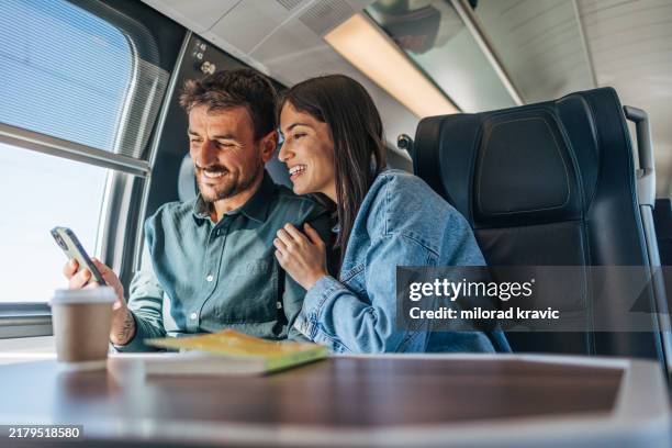 an adult, cheerful couple traveling by train. - carruagem imagens e fotografias de stock