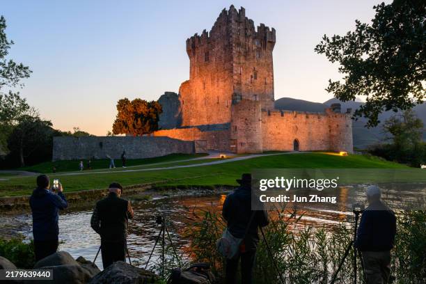 photographers in front of the illuminated ross castle in the evening - county kerry stock pictures, royalty-free photos & images