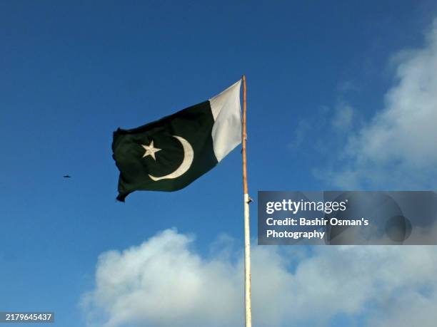 pakistani flag waving before the floating clouds - pakistani flag stock pictures, royalty-free photos & images