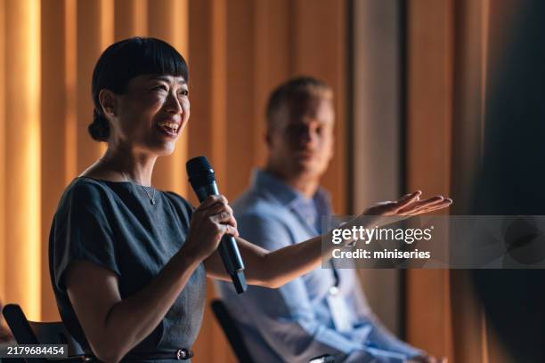 donna che parla a una conferenza aziendale con un pubblico attento - discorso programmatico foto e immagini stock