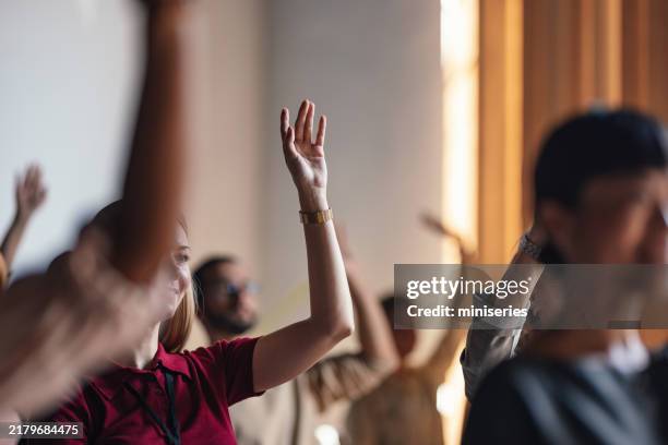 pubblico coinvolto che alza la mano durante la conferenza di business lecture - anello di fidanzamento foto e immagini stock