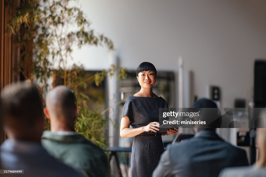 Confident Presenter Leading Business Conference with Engaged Audience